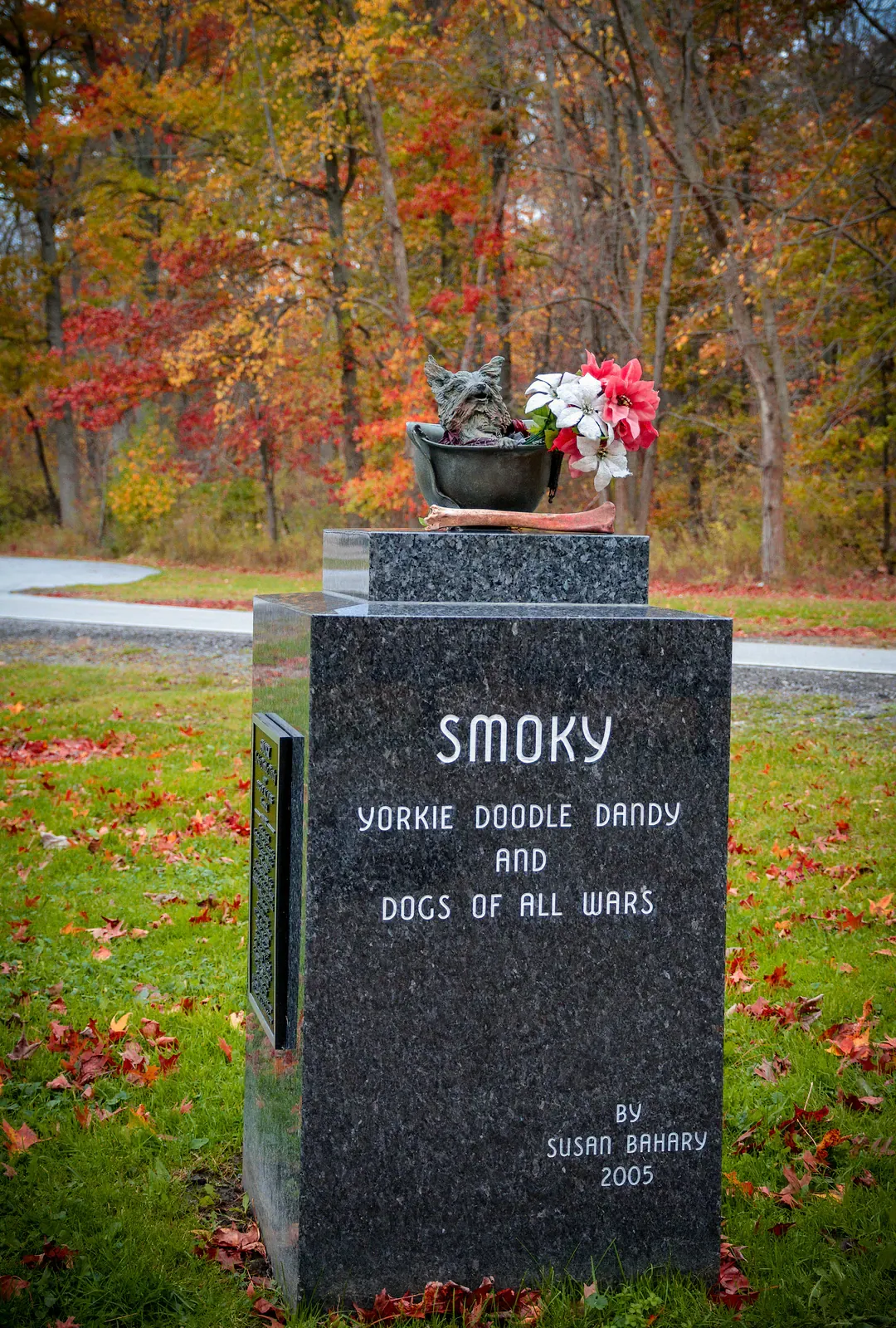 Memorial to Smoky, the Yorkie war dog, with flowers on the granite marker